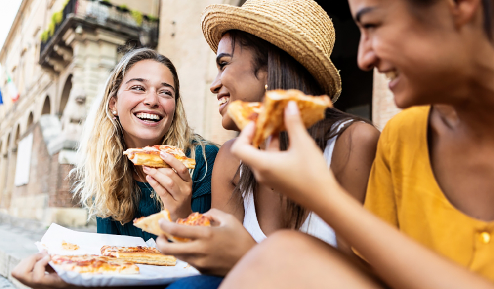 Estudiantes comiendo pizza juntos