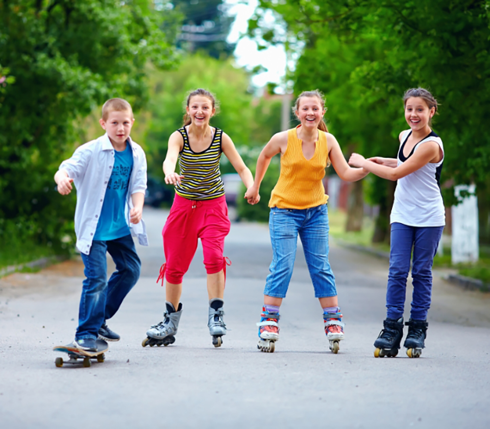 Kinder fahren Skateboard und Inlineskaten